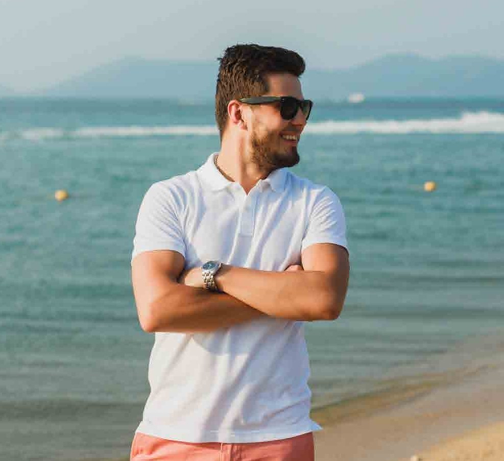 Model in a white polo shirt by the sea