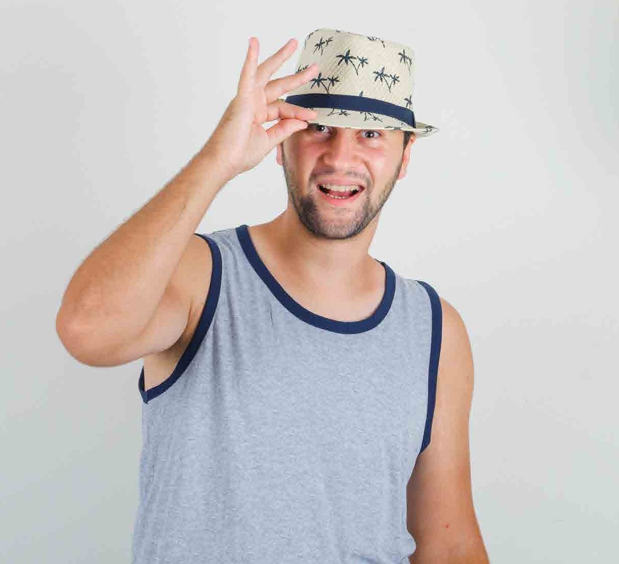 Model in a navy trimmed vest and straw hat