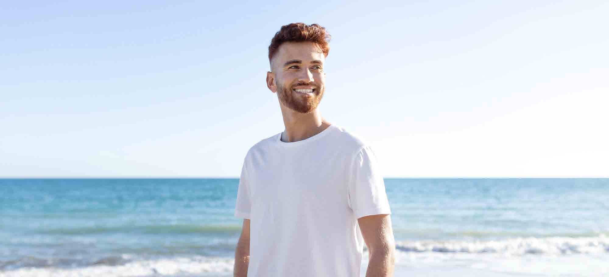 Model in a white cotton T-shirt on a summer shoreline